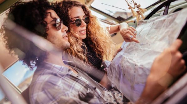 Hipster Friends Sitting in Retro Van Looking at Map