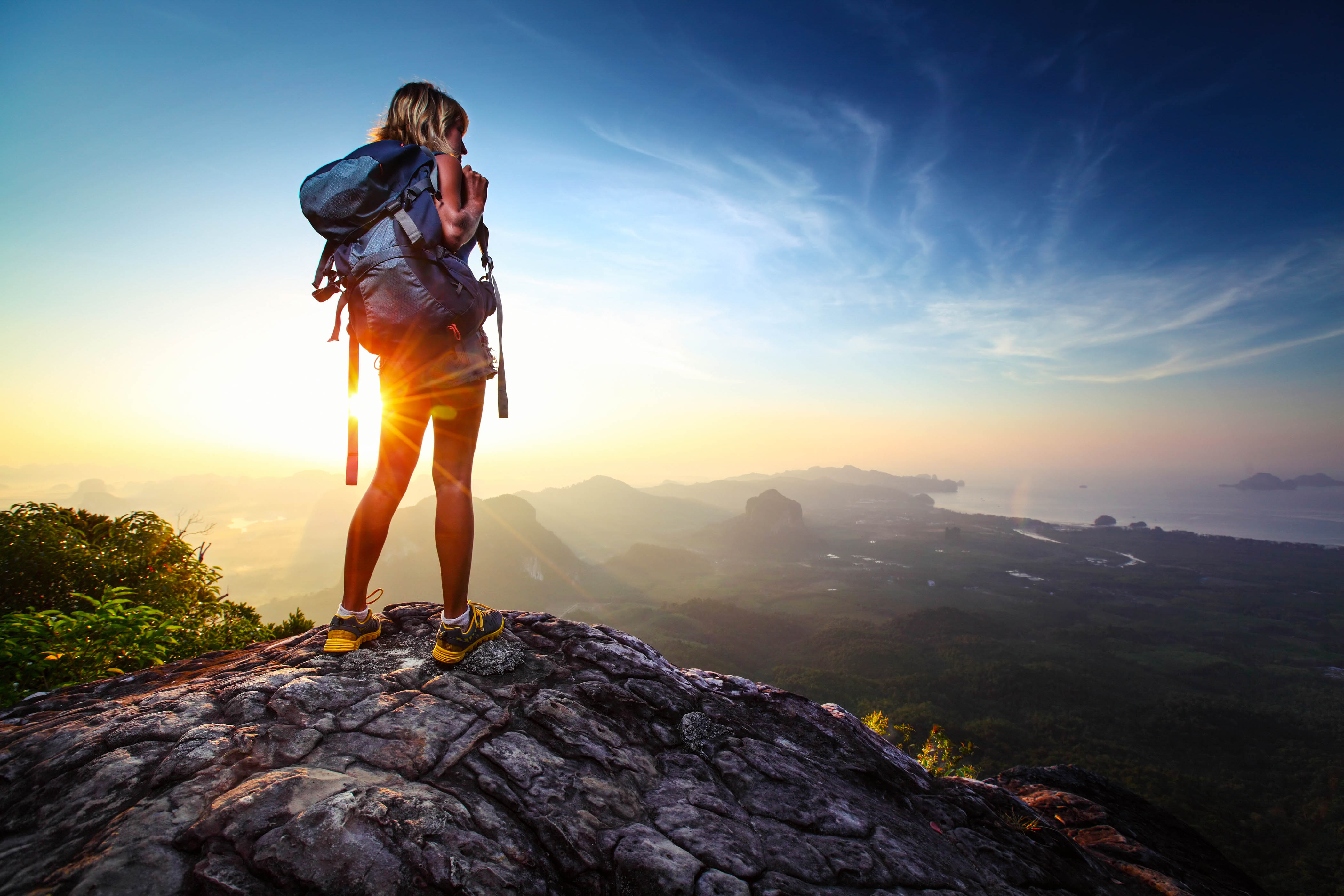 Een beginnende backpacker kijkt uit over de klif
