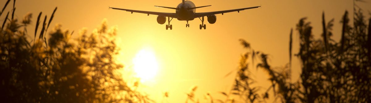 Een vliegtuig stijgt op tijdens zonsondergang