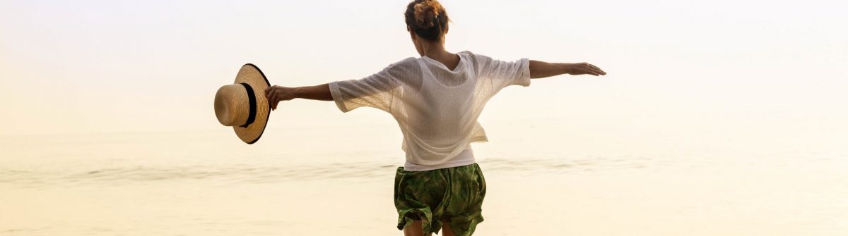 Gluckliche-Frau-mit-Stroh-hutte-am-Strand-iStock-538332160-2